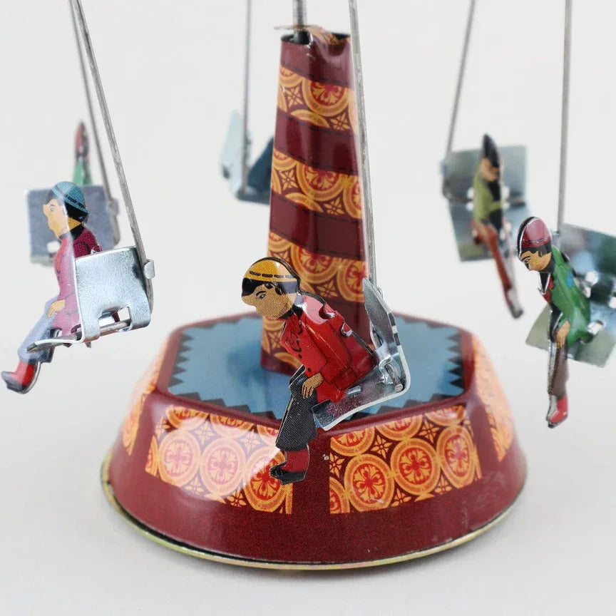 Blechspielzeug-Karussell Schaukel Jahrmarkt Altmodisches Zinnspielzeug 01 Miniatur mit bunten Schaukelplätzen und drehender Plattform.