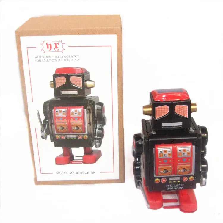 Robot metalic vintage – Obiect de colecție retro cu mecanism de întoarcere, în design negru, în fața ambalajului original.